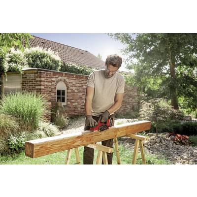 A man is sanding a wooden beam on two trestles in a sunny garden. A brick house is visible in the background.