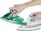 A hand removes a green iron from the white charging stand.