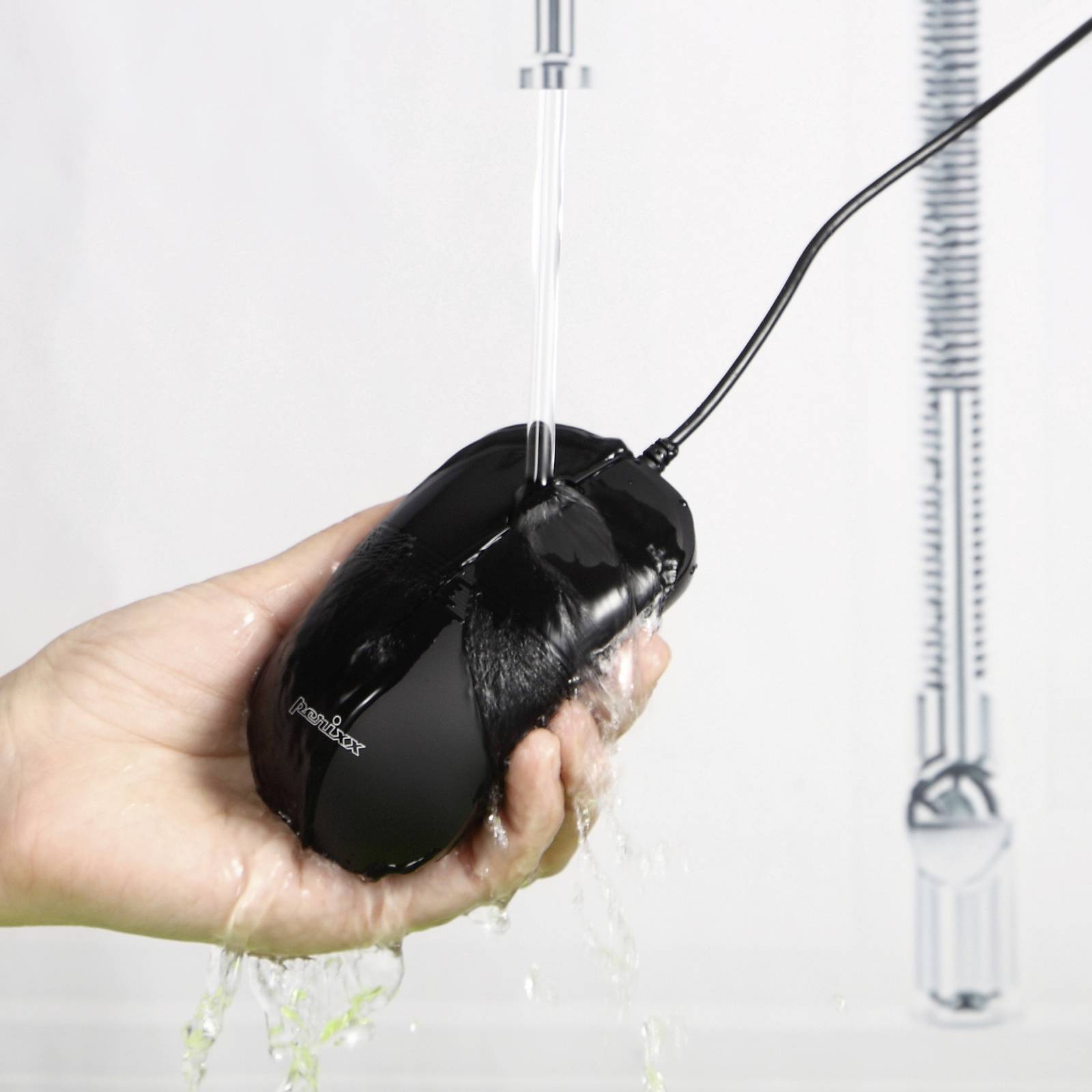 A hand holds a black computer mouse being washed under a running tap, indicating its water resistance.