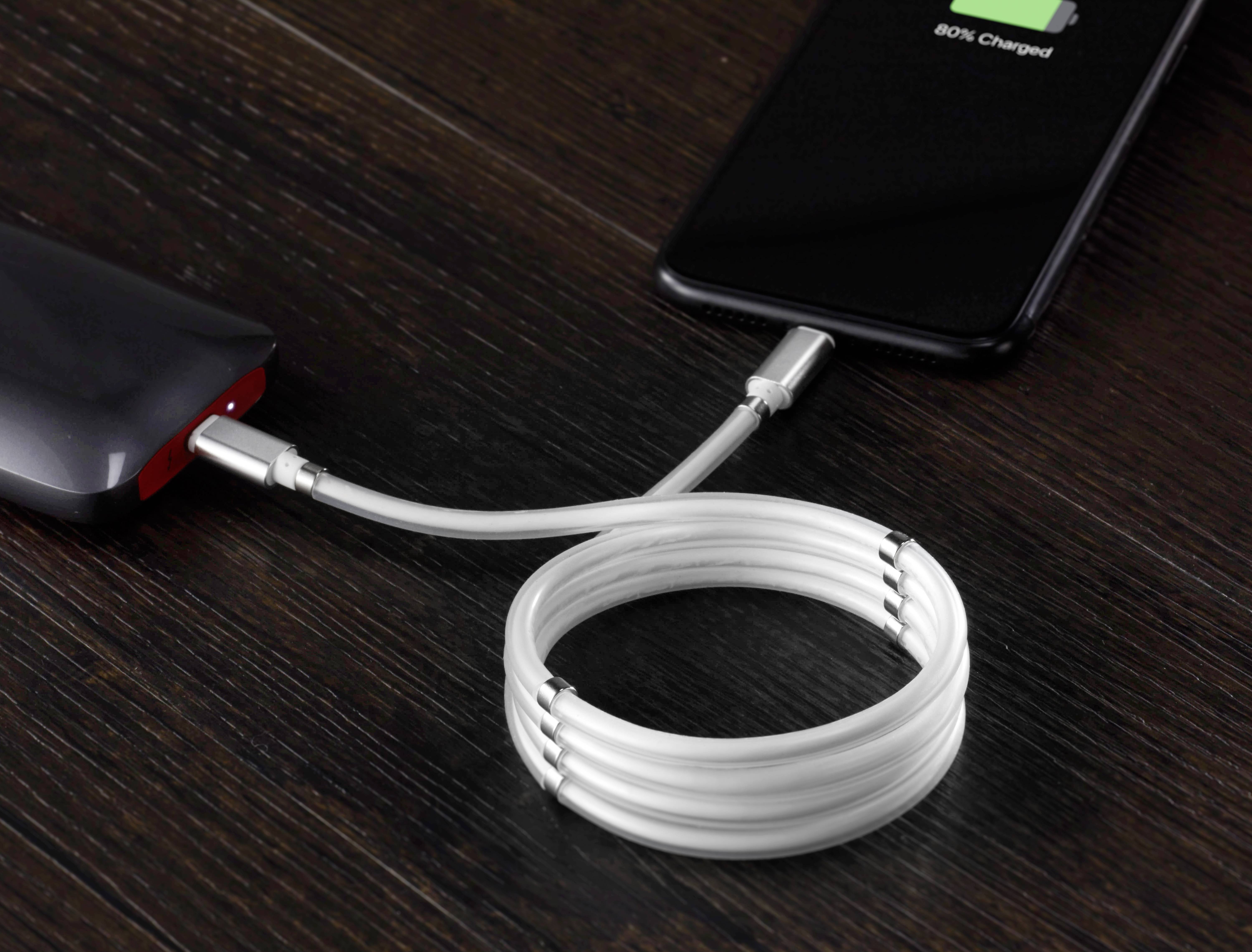 A mobile phone is being charged from a power bank via a USB cable. The screen displays '80% charged'.