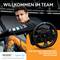 A racing driver in an orange-black suit poses with a racing steering wheel. At the top it says 'Welcome to the Team', at the bottom 'Bring the thrill of motorsport home'.