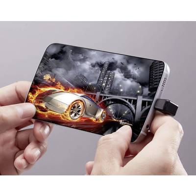 A hand is holding a smartphone displaying a video game with a burning racing car in an urban landscape.
