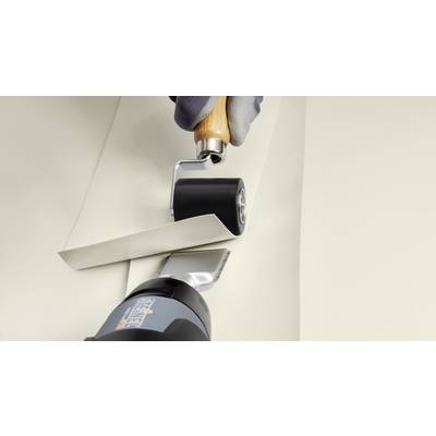 'Close-up of hands using a roller tool to press a wallpaper edge against the wall; an edge roller and wallpaper smoother are in use.'