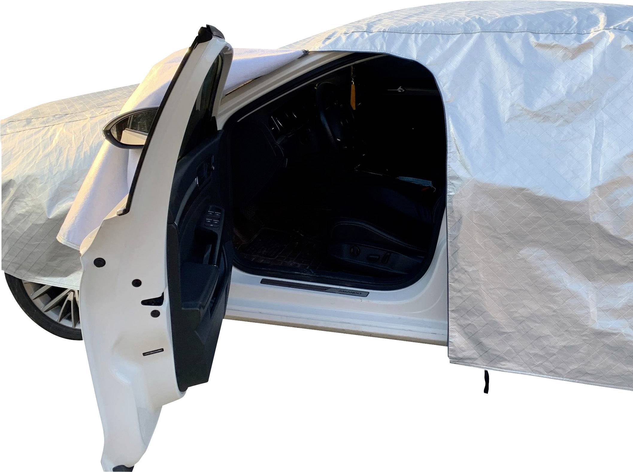 A white car with its driver's door half open, covered by a silver tarpaulin.