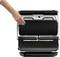 A hand opens a contact grill with a ridged grilling surface, ready for use in the kitchen.