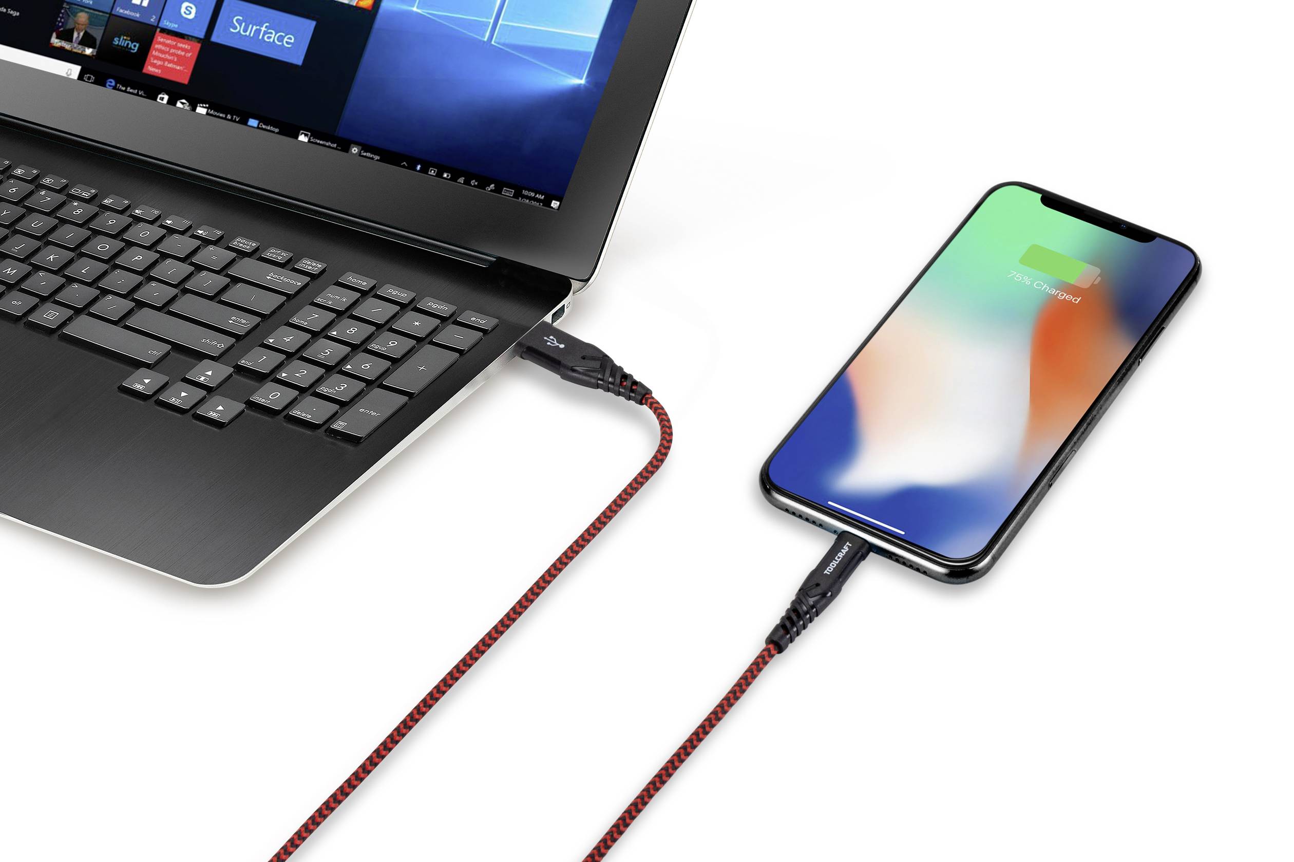 A laptop is connected to a smartphone via a red and black cable, with the smartphone screen displaying '100% charged'.
