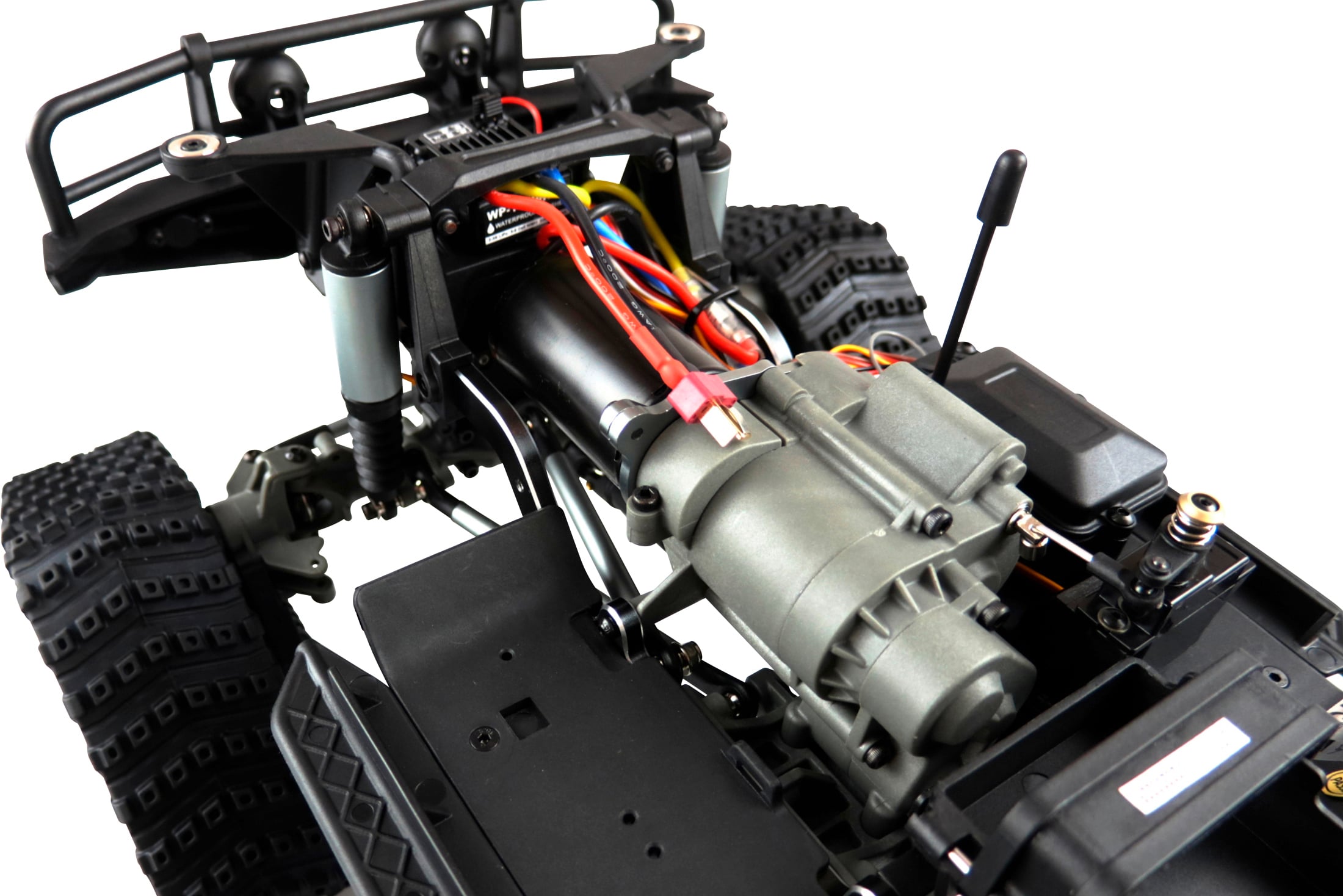 Close-up of a remote-controlled off-road vehicle without bodywork, showing the engine and wiring.