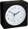 A square, black alarm clock with a white dial and black numbers. The hands are showing the time as 10:09.