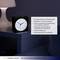 An analogue alarm clock with blue backlighting sits on a bedside table. The text describes its functions, such as the snooze feature and soft illumination.