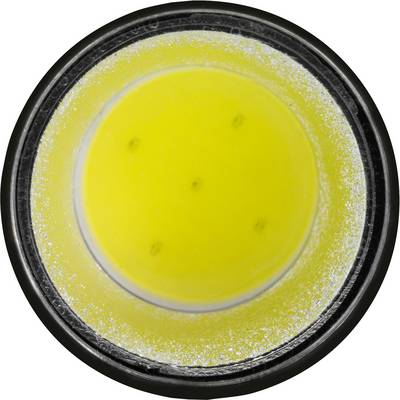 Dose filled with yellow powder, evenly distributed. Top-down view, round container with black rim.