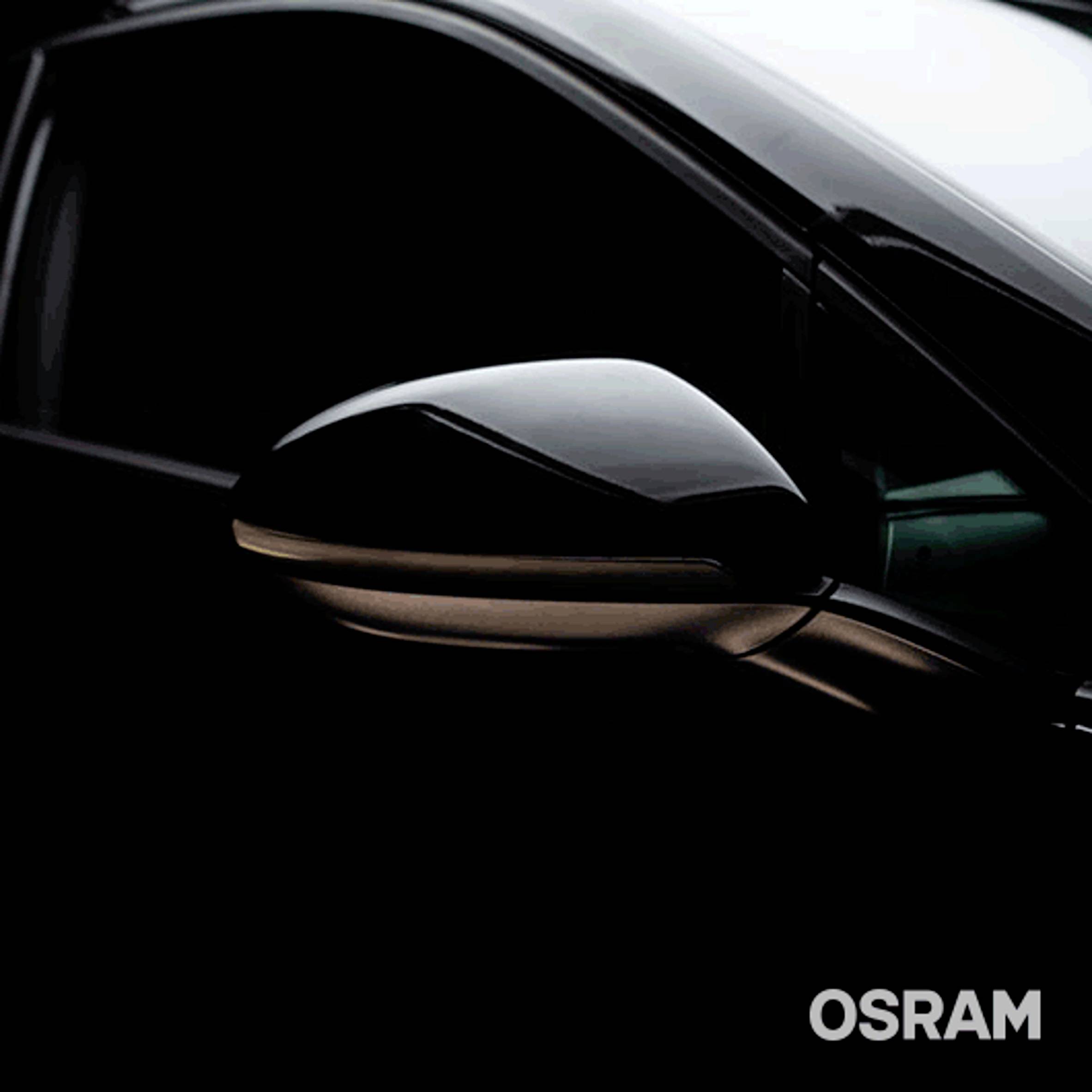 Close-up of a vehicle in darkness, showing the wing mirror and a faint light. 'OSRAM' brand logo in the corner.