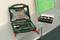 An opened toolbox with various attachments and drill bits sits on a table. Beside it lies a smaller box of screws.