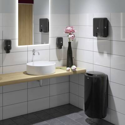 Modern bathroom with washbasin, mirror, hand dryer and black accessories. A vase with a pink flower stands on the shelf.