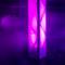 A tall, luminous column in a room bathed in purple light and mist, surrounded by spotlights creating a mystical atmosphere.
