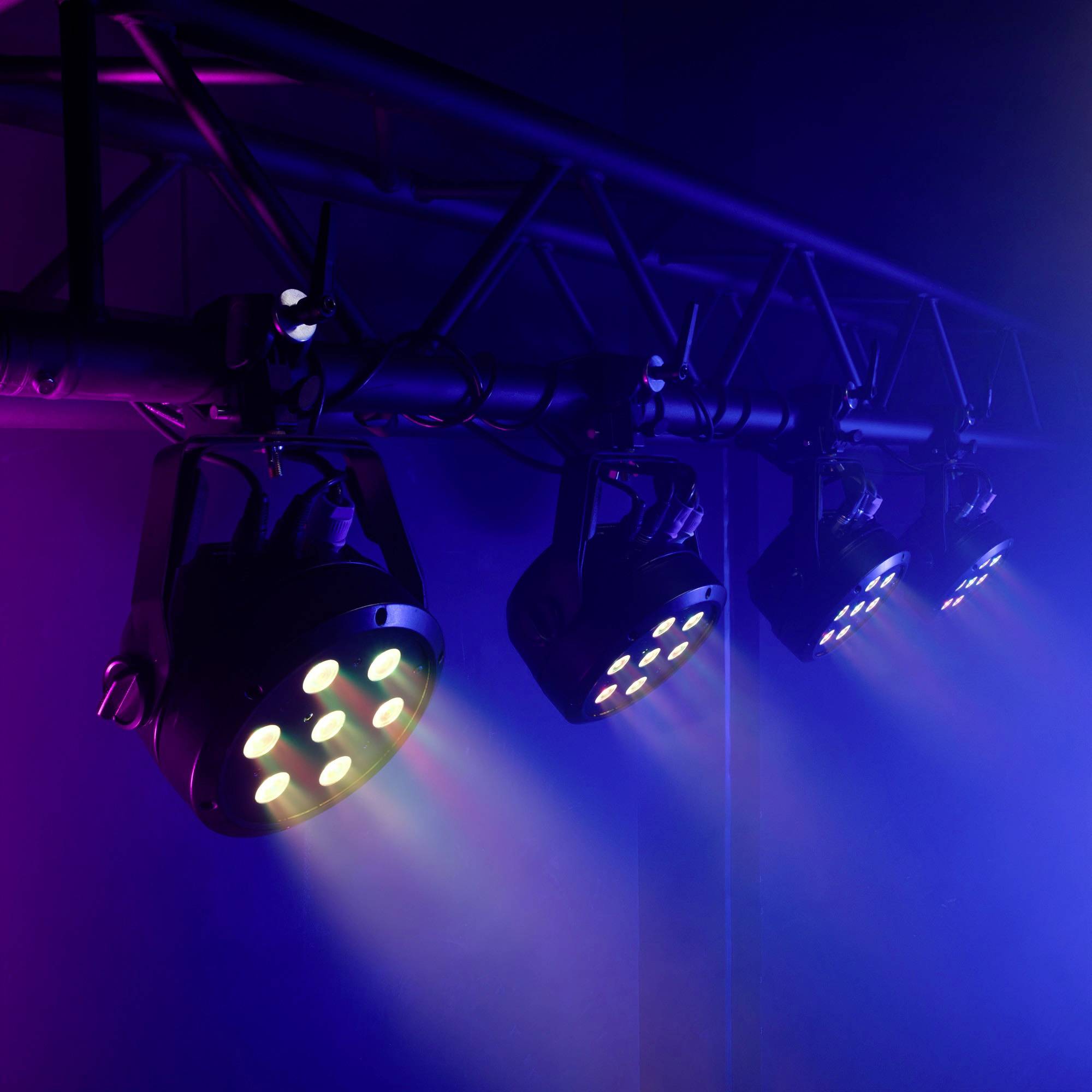 Stage spotlights beam in various colours across a stage, creating a vibrant and atmospheric lighting effect.