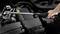 A torque wrench is being used by hand to tighten a screw in an automotive component area. Mechanical maintenance scene.