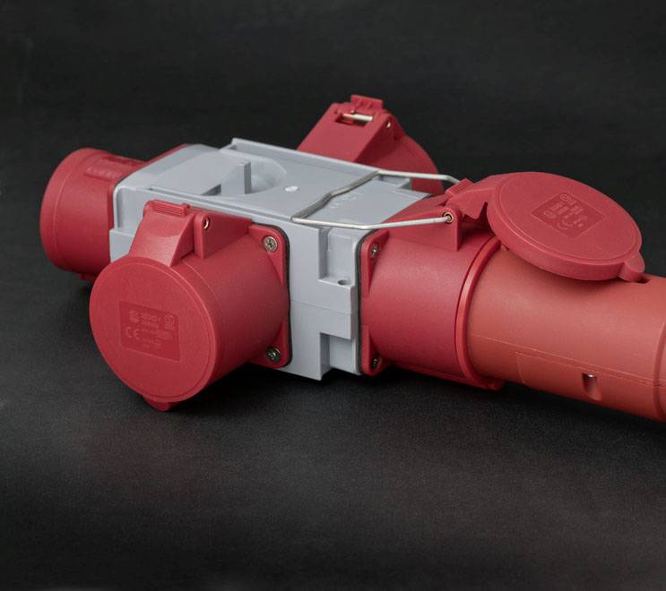 'Red and grey industrial connector on a black background.'