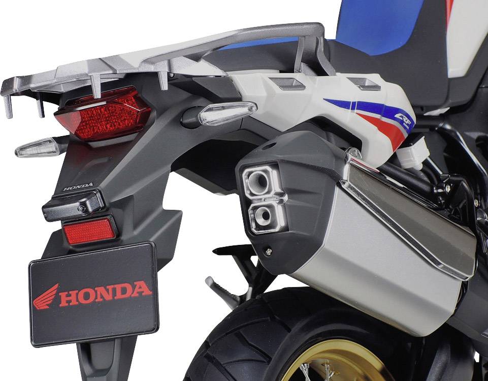 Rear view of a motorcycle with a 'Honda' logo on the number plate holder. The exhaust and the rear section of the motorcycle are visible.