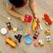 A child plays on a wooden floor with colourful toys: a Lego car, Mickey and Minnie Mouse figures, presents, a balloon and more.
