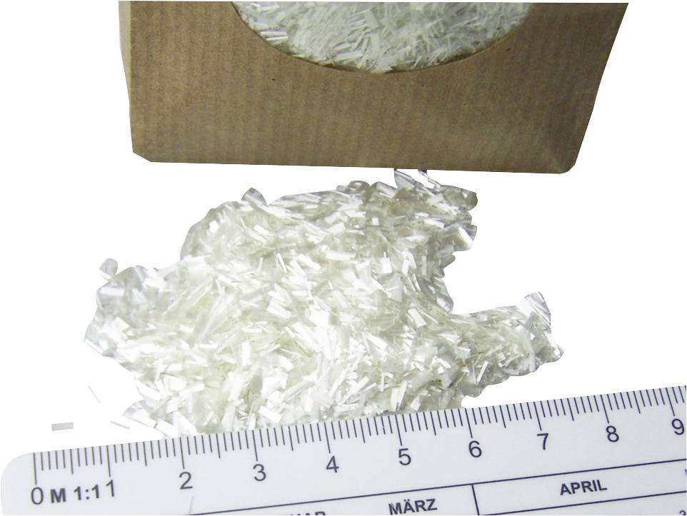'White, crystalline flakes beside a ruler and a cardboard container.'