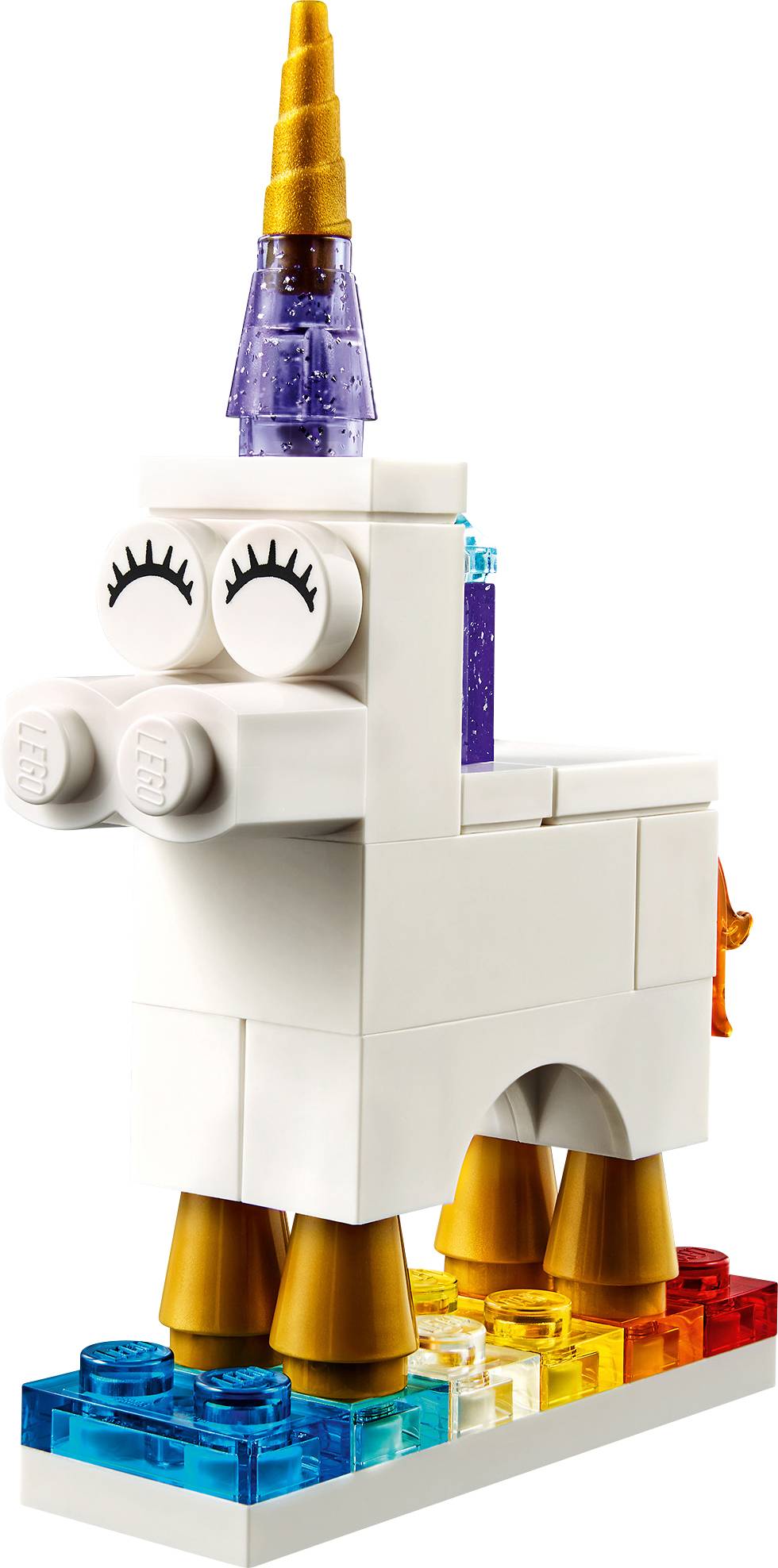 White LEGO unicorn figure with a yellow horn and rainbow base. It has expressive eyes and colourful details, standing on clear building blocks.