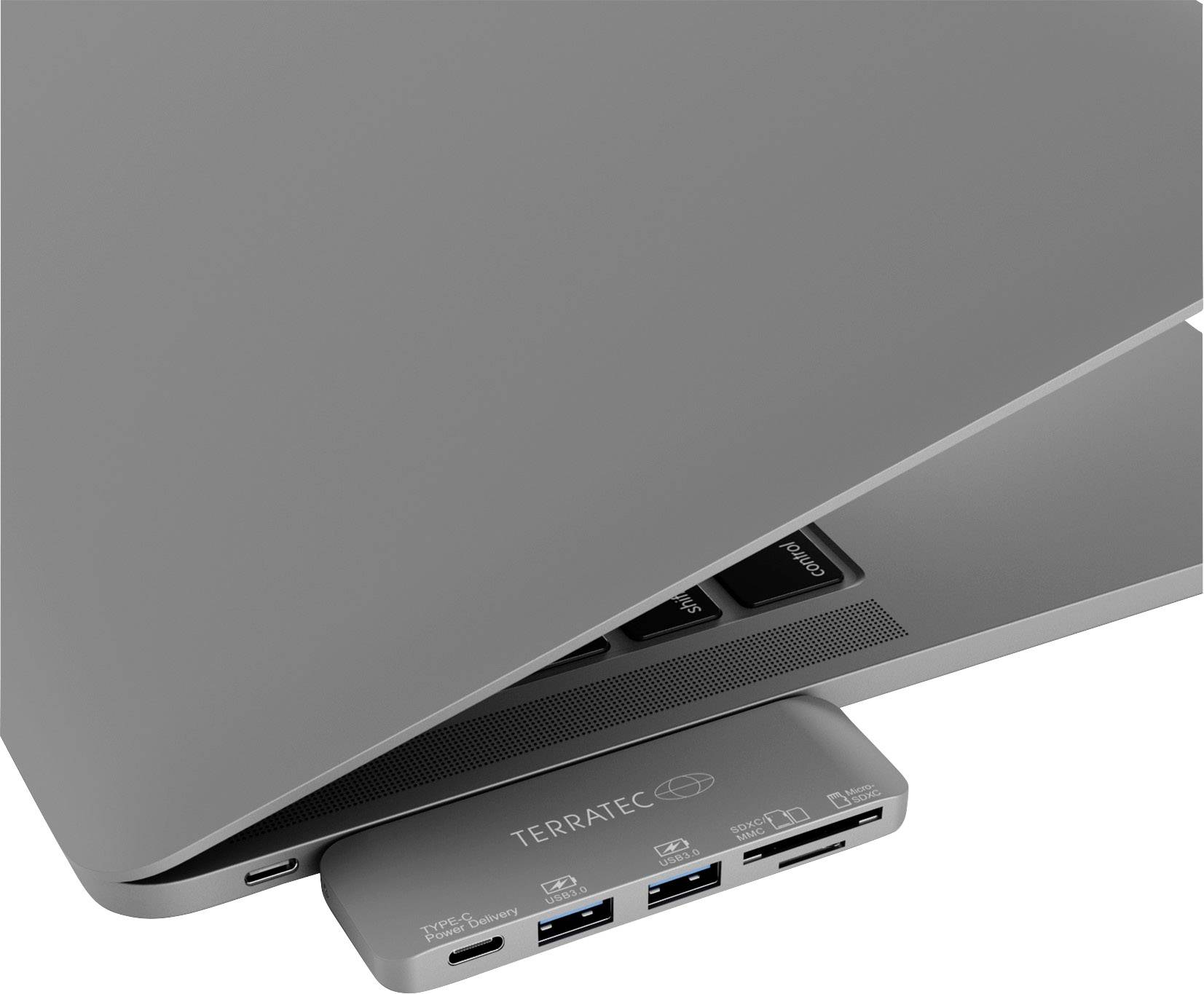 Grey-silver laptop with partially closed lid, with a USB hub plugged in underneath. On the hub: brand name and various connection ports.