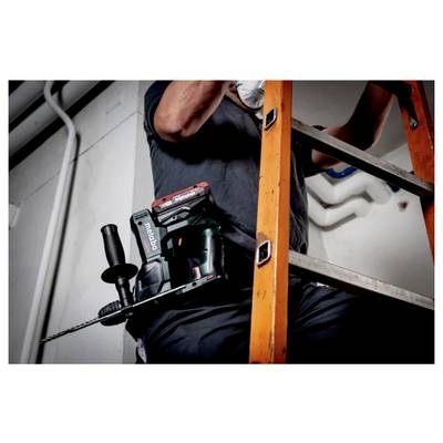 A person is standing on a ladder using a powerful cordless drill for construction work, showing an industrial setting.