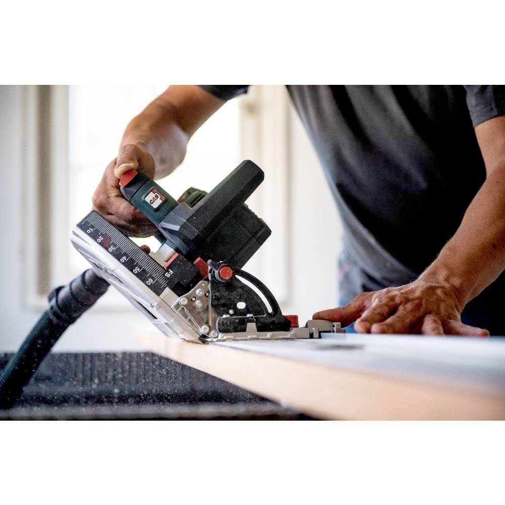 A person uses a power tool to precisely cut wood on a workbench in a workshop, focusing on the measurement and alignment.