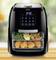 Air fryer with digital display showing '3:40'. Inside are trays with fried chicken, asparagus, and lemon slices.