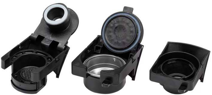 Three coffee machine filter holders side by side. Each holder has an open lid, revealing its inner surfaces.