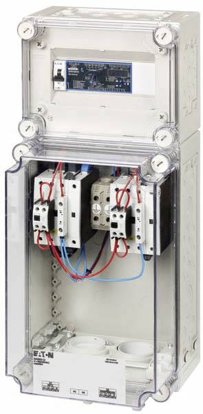 A switchboard with a transparent casing reveals electrical components and wiring. The upper compartment contains a control circuit board.