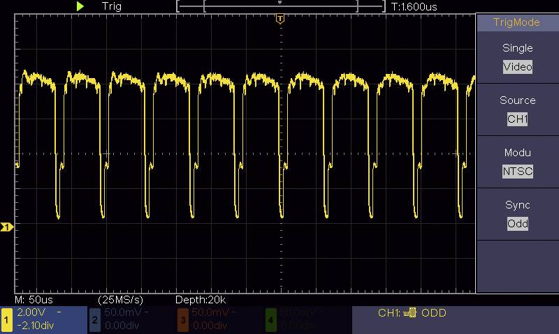 'Oscilloscope screen shows NTSC video signal. Yellow waveform displays periodic pulses with synchronised peaks. Axis: 2.00V/Div, 50.0µs/Div.'