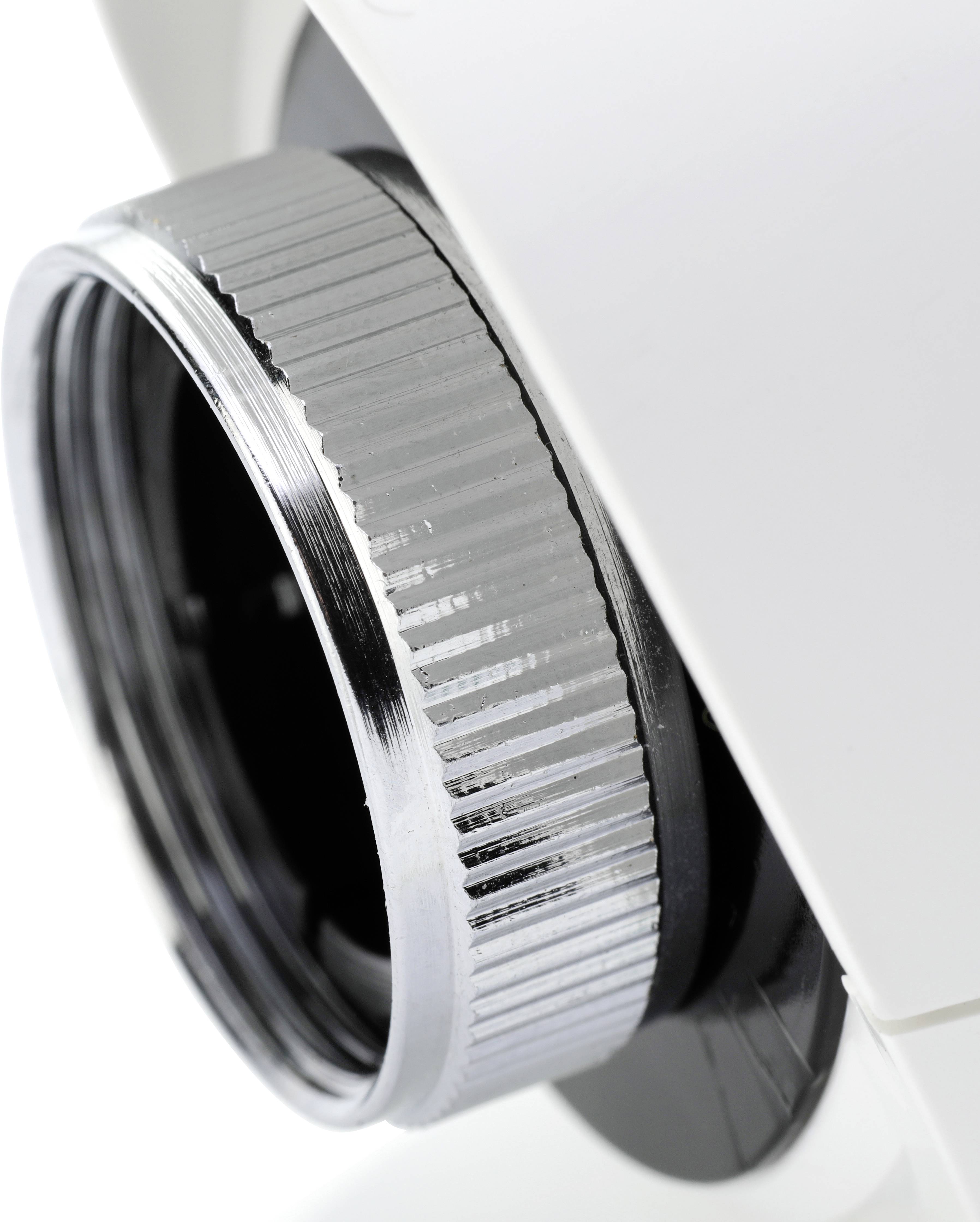 Close-up of a chrome-plated threaded connector on a white plastic housing, potentially part of an optical device.