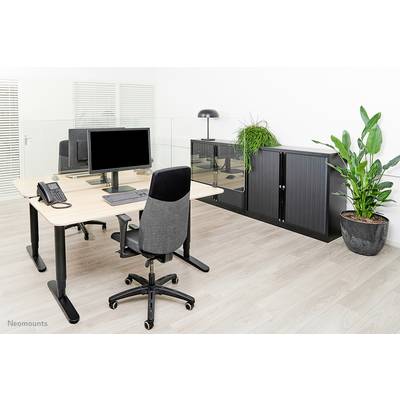 A modern office space with a desk, computer, office chair, telephone, and plants. Filing cabinets in the background.