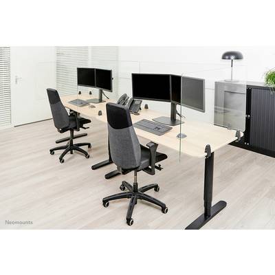 Two modern workstations with monitors, keyboards and office chairs on light laminate flooring, separated by glass partitions.