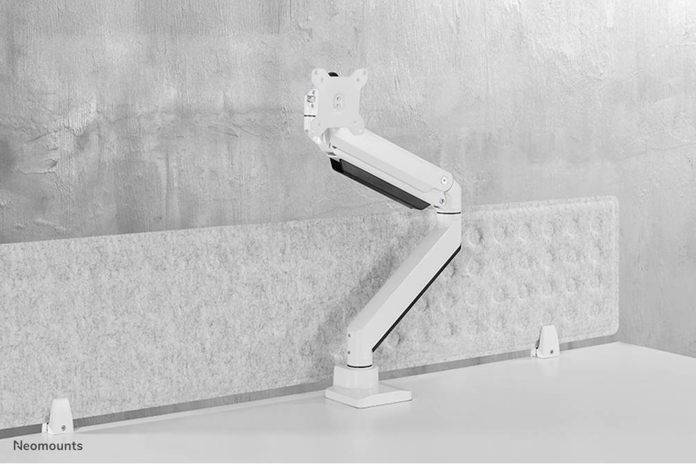 Height-adjustable monitor arm with a grey wall as a background, mounted on a white desk.