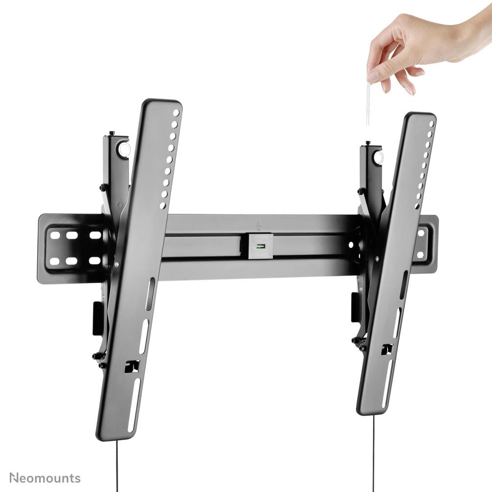 A hand adjusts a Neomounts TV wall mount, with the tilting mechanism visible. Product for flexible television mounting.