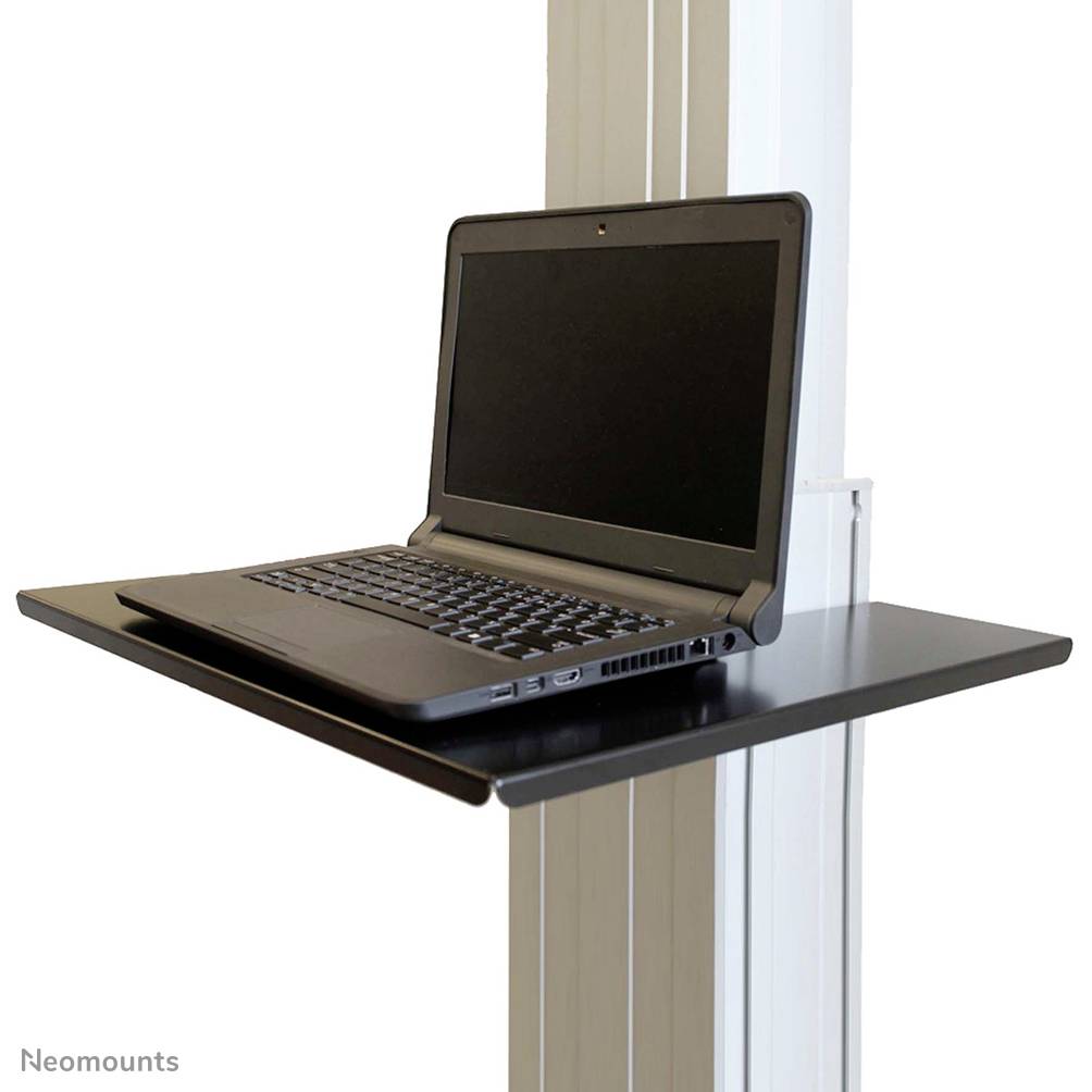 A laptop is open on a black table mounted on a light-coloured wall. The screen is dark.