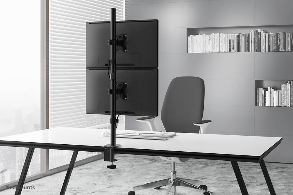 A modern office space with a desk featuring a dual monitor stand. In the background, a grey-white bookshelf.