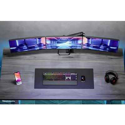 A desk with a triple monitor setup, backlit keyboard, mouse, smartphone, and headphones; ideal for gaming.