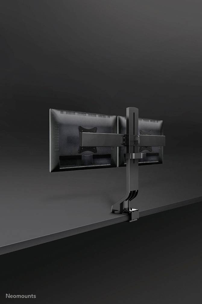 Two monitors mounted on a double monitor arm against a wall, demonstrating a robust and space-saving workstation solution.