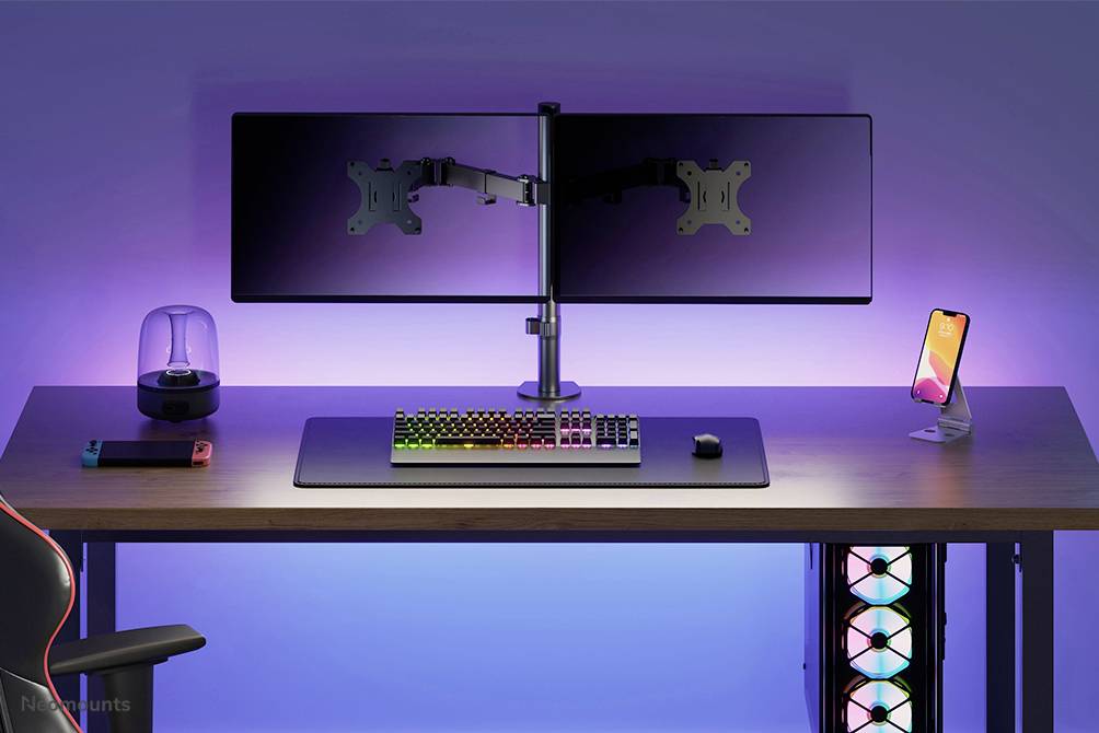 A modern desk with two mounted monitors, an RGB keyboard, a mouse, a smartphone holder, and LED lighting.