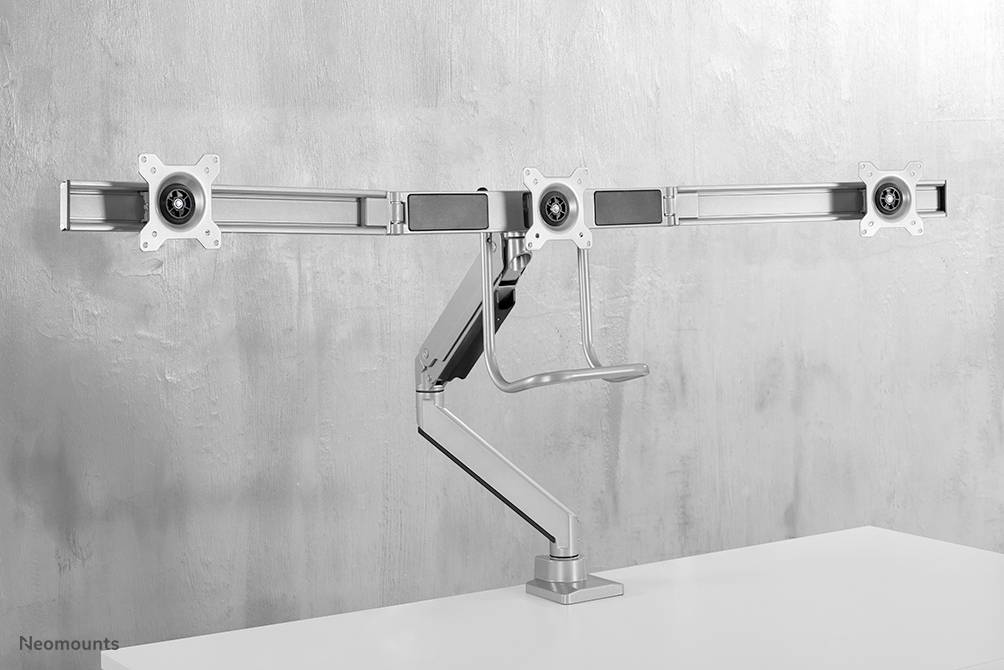 Metal monitor mount on a desk, suitable for three screens. Minimalist design, adjustable arms.