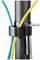 A black cable tie secures a blue and a yellow cable to a pipe. Two metal tools are also attached to the cable tie.