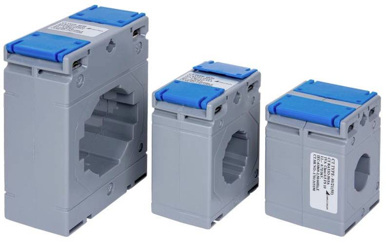Three grey and blue current transformers of various sizes positioned side by side, used for measuring electrical currents in switchgear installations.