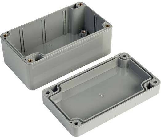 Two grey rectangular plastic enclosures, opened. They are intended for electrical components, with pre-drilled holes at the corners.