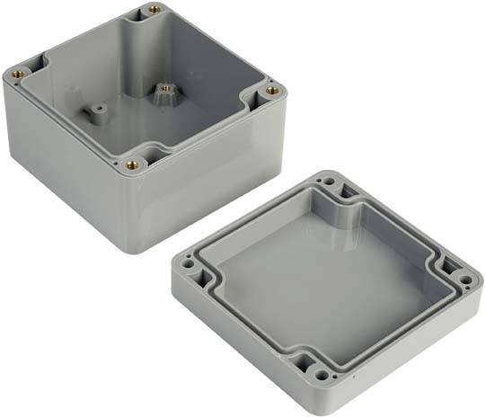 A grey electrical socket box with the cover removed, showing four screw holes and an internal wiring space, set against a white background.