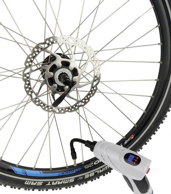 A bicycle tyre is being inflated with a portable electric air pump.