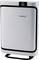 A white air purifier with a black border stands against a neutral background. LED indicators are visible at the top.
