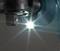Close-up of a glowing LED light on a mechanical device. The light shines brightly forward and highlights the tool.